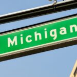 a green street sign that reads Michigan with an arrow on it