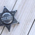 a sterling silver sheriff badge on a wooden table