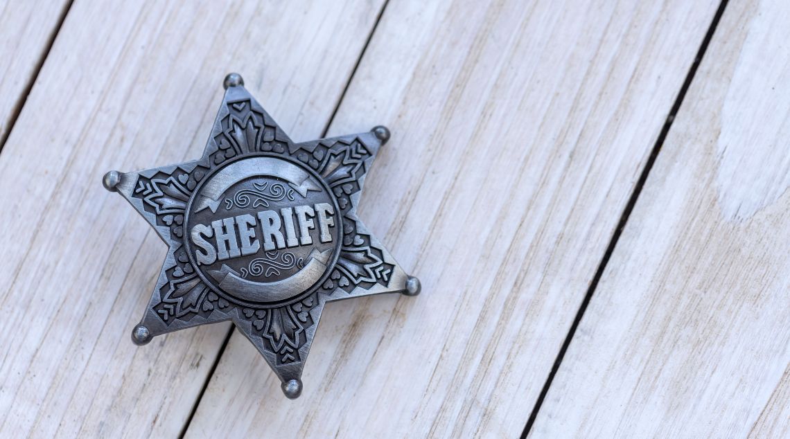 a sterling silver sheriff badge on a wooden table